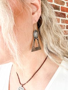 Bourbon Cowgirl earrings are the best gift for an authentic cowgirl. Spirited women will boldly and proudly wear such a unique and beautiful pair of earrings. This showpiece earring set features a gorgeous sterling silver concho with a copper dangle that is hand stamped with cowgirl symbols and lettering. Handmade in Idaho by Weathered Soul exclusively for Bourbon Cowgirl. Limited Edition, high quality jewelry that is as unique and authentic as you! Due to their handcrafted nature, slight variat Concho Drop Earrings, Western Style Dangle Earrings For Pierced Ears, Nickel-free Western Style Earrings, Nickel-free Adjustable Western Earrings, Western Style Earrings For Gifts, Adjustable Nickel-free Western Earrings, Silver Concho Earrings For Gift, Silver Concho Earrings As A Gift, Western Style Teardrop Silver Jewelry