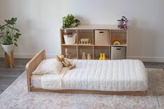 The oak montessori floor bed with one headboard and a six cube shelf in the background Floor Bed Toddler, Low Floor Bed, Wooden Toddler Bed, Room Sharing, Modular Bed, Low Profile Bed Frame, Kid's Bed, Floor Bed Frame, Bed Wooden