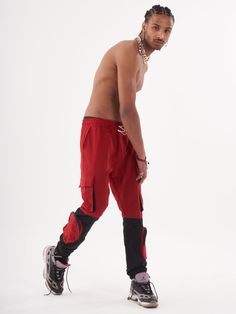 Double-color red and black joggers with four functional cargo pockets on the knees and elastic ankles. FEATURES Slim Fit Made up of 95% Cotton and 5% Elastane Jogger comfort Drawstring waist SIZE GUIDE Model's height and weight: 6"1 feet & 180 lbs. (185 cm & 82 kg ) Model wears size: L Red Sports Joggers With Elastic Waistband, Functional Cargo Jeans For Streetwear, Sporty Cargo Style Joggers For Streetwear, Red Athleisure Bottoms For Streetwear, Utility Streetwear Joggers With Functional Pockets, Red Athleisure Bottoms With Pockets, Utility Joggers With Functional Pockets For Streetwear, Red Cargo Pants For Streetwear, Functional Streetwear Joggers With Hip Pockets