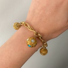 This unique bracelet seamlessly unites different eras in a truly captivating way. The 18k gold bracelet dates to the 1860s; while each of the 14k gold charms was originally a Victorian era hat pin. The piece measures 7.75 inches long by 1.25 inches wide and weighs 19.39 grams. It is in great condition. Note: The vintage box in the photo is for display purposes only and is not included with the bracelet. Materials: 14k gold, 18k gold. Vintage Gold Charm Bracelet Luxury, Luxury Antique Bracelet For Gift, Luxury Heirloom Style Bracelets With Vintage Charm, Luxury Vintage Engraved Charm Bracelet, Bracelet Materials, 18k Gold Bracelet, Different Eras, Gold Charms, Hat Pin