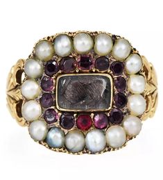 This is a beautiful Georgian mourning ring. I have always loved mourning rings for what they represent...their sentiment, devotion and love.  This is a very special ring and in excellent condition, considering its age.  The ring is set in approximately 5 grams of gold. Hallmark on the inside (please see photographs.) Lovely garnets and seed pearls in a halo setting. If you notice in the center, I tried to capture what looks like to be braided hair...a very common theme in Georgian Mourning Rings Heirloom Ring Jewelry For Memorial, Victorian Memorial Jewelry Ring, Heirloom Oval Ring For Memorial, Heirloom Oval Rings For Memorial, Victorian Cabochon Wedding Rings, Heirloom Multi-stone Pearl Ring As Gift, Heirloom Multi-stone Pearl Ring Gift, Heirloom Cabochon Rings For Wedding, Antique Pearl Ring With Gemstone For Anniversary