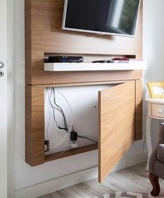 a flat screen tv mounted to the side of a wooden cabinet in a living room