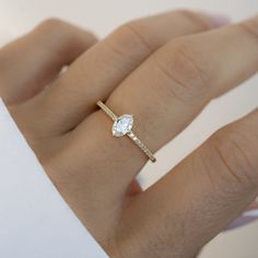 a woman's hand with a diamond ring on it