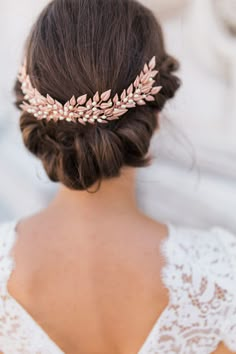 the back of a woman's head wearing a wedding hair comb with leaves on it