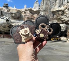 someone is holding up some mickey mouse magnets in front of a star wars theme