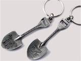 two metal shovels and a wrench shaped keychain are shown on a white background