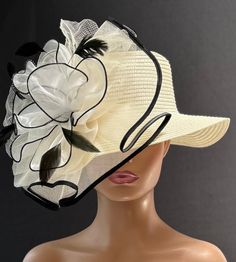 The featured hat is an ivory straw hat with a lovely crinoline design in white, black and ivory. A large ivory crinoline disc trimmed in black sits at the side of the hat. In its center is a white large  flower also trimmed in black. This organza flower is made of large white petals.  This hat will be perfect for Church or for the Kentucky Derby.  It's also perfect as a Tea Party Hat, Easter Hat, Wedding Party hat, Garden Party Hat and any  special  occasion. Brim: 3" Rise: 3.75" Size:  Internal draw string to adjust size White Fedora Hat For Kentucky Derby, Elegant White Fedora Straw Hat, Cream Fedora Sun Hat For Kentucky Derby, Kentucky Derby Cream Fedora Sun Hat, Cream Fedora Panama Hat For Kentucky Derby, White Straw Hat With Short Brim For Country Events, White Curved Brim Straw Hat For Country Events, Adjustable White Straw Hat For Kentucky Derby, White Adjustable Straw Hat For Kentucky Derby