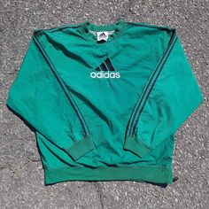 Staying true to my wife's era is this, 90s style fit that all the coolest of kids rocked! Cop this gorgeous vintage Adidas pullover windbreaker sporting the black racer stripe sleeve half-side zip sized as a large in the color green. Please, before my wife decides to keep it. Haha. Crew Neck Outerwear With Three Stripes For Streetwear, Spring Sporty Crew Neck Track Jacket, Sporty Crew Neck Track Jacket For Spring, Streetwear Long Sleeve Windbreaker With Three Stripes, Green Sporty Track Jacket For Streetwear, Sporty Track Jacket With Three Stripes And Crew Neck, Urban Crew Neck Track Jacket For Sports, Sporty Crew Neck Track Jacket For Streetwear, Green Sporty Sweatshirt For Outdoor Activities