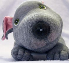 an elephant stuffed animal sitting on top of a white surface with its eyes wide open