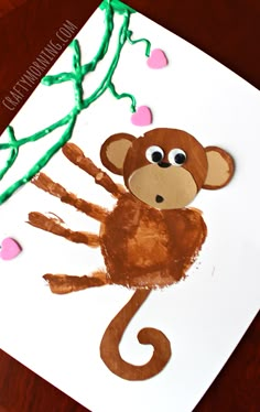 a paper plate with a monkey on it and hearts hanging from the tree branch in the background