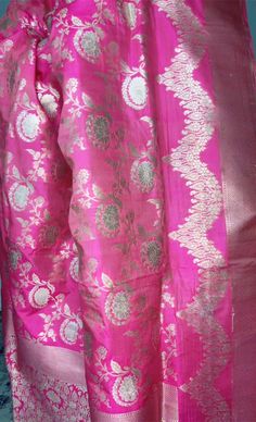 This stunning pink 100% Mulberry Katan silk saree is handwoven in Banaras, known for its intricate designs and high-quality craftsmanship. The saree features a beautiful shade of dual pink with gold and silver zari jaal work creating a mesmerizing effect. Loolong for a distinct saree - this is the one with silver zari outlining . The saree is perfect for any special occasion, such as a wedding, festival, or formal event. Comes finished with hand fall and Pico. And a blouse piece with zari border. Silk Mark Certified Note: Colors that show up on your screen may vary slightly from the actual product due to variations in settings. Also, the actual product may appear to be different hues depending on the ambience lighting.Note: There may be very slight inconsistencies such as in the weave/moti Pink Paithani Silk Traditional Drape Blouse, Pink Raw Silk Salwar Kameez For Traditional Ceremonies, Pink Raw Silk Traditional Wear For Ceremonies, Pink Raw Silk Dupatta For Traditional Ceremonies, Festive Pink Katan Silk Salwar Kameez, Pink Chanderi Blouse For Traditional Ceremonies, Pink Salwar Kameez With Pallu For Traditional Ceremonies, Pink Traditional Wear With Pallu For Transitional Season, Pink Salwar Kameez For Celebration