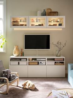 a dog laying on the floor in front of a flat screen tv and entertainment center