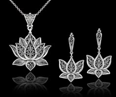 "This 925 sterling silver filigree art blossoming lotus flower pendant and dangle drop earrings set is a true work of art. The filigree silverwork is delicate and intricate, creating a beautiful open-air design that showcases the lotus flower in full bloom. The dangle drop style of the pendant and earrings adds a touch of movement to the overall design, making this set both stylish and eye-catching.       Whether you're dressing up for a special event or just want to add some beauty to your everyday look, this set is sure to make a statement. The sterling silver material also ensures that this set will last for years to come, making it a great investment piece for your jewelry collection. Earrings; The length of the earrings is 1.70\"  and the width is 0.90\". The total weight is 7.50 gr. Filigree Dangle Jewelry For Gifts, Filigree Dangle Earrings For Gifts, Intricate Design Drop Earrings For Gift, Fine Jewelry With Filigree Dangle, Fine Jewelry Dangle Earrings With Filigree, Traditional Pierced Flower Jewelry, Delicate Sterling Silver Filigree Jewelry, Teardrop Jewelry With Intricate Design For Gifts, Traditional Flower-shaped Jewelry With Matching Earrings