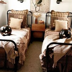 two twin beds in a bedroom with brown and tan blankets on top of the covers