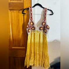 a yellow dress hanging on a wooden door