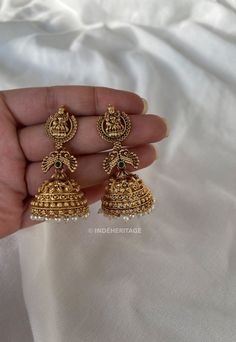 Step into the world of timeless elegance with our Jhumka Earrings. These exquisite earrings are a perfect blend of traditional design and contemporary style, making them a must-have accessory for any occasion. The jhumka style is inspired by traditional South Indian jewelry, known for its intricate craftsmanship and ornate designs. These earrings beautifully capture the essence of Indian culture and heritage, making them a timeless treasure to cherish. Whether you're attending a wedding, festival, or any special event, these Jhumka Earrings will complement your traditional attire flawlessly. They are also versatile enough to add a touch of elegance to your everyday look, making them a versatile addition to your jewelry collection. --------------------------------------------------------- C Bridal Temple Jewellery, Wedding Brass Jhumkas With Intricate Design, Traditional Ceremonial Hallmarked Jhumkas, Traditional Brass Wedding Jhumkas, Traditional Hand-set Dangle Jhumkas, Indian Culture And Heritage, Festive Ornate Brass Jhumkas, South Indian Jewelry, Indian Culture