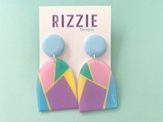 Featuring a geometric pastel pink, yellow and purple drop and blue top. Approximately 7cm long by 3.5cm wide. All Rizzie Design earrings have surgical steel posts. They are all designed and handmade by me (Libby), therefore you may receive a pair slightly different to the pair in this listing and they may have minor but unique imperfections. We do our best to capture the earrings true colours in our photographs, however, lighting and screens may vary the colours slightly. We hope you like them. Retro Purple Jewelry For Gifts, Handmade Pastel Jewelry For Gifts, Pastel Handmade Jewelry Gift, Handmade Blue Geometric Earrings, Pastel Drop Earrings Jewelry As Gift, Playful Purple Earrings For Gift, Playful Purple Earrings For Gifts, Pastel Dangle Jewelry For Gifts, Colorful Dangle Earrings For Gift