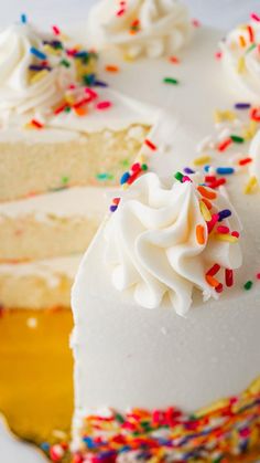 a piece of cake with white frosting and colorful sprinkles on it