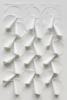 an abstract white paper sculpture with circles on it