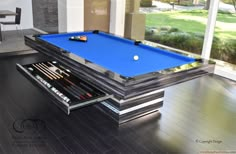 a pool table in the middle of a living room with an open drawer underneath it