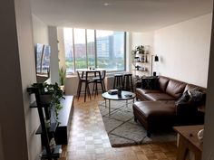 a living room filled with furniture and tall windows