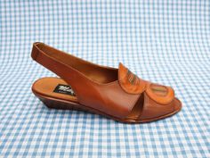 "These shoes are previously unworn ex shop stock from the 1980s. They were handmade in Italy and have been made from genuine Italian leather. They have a small wedge heel, a slingback strap at the back and a leatherwork circle pattern on the front. They are very good quality \"Mayfair\" shoes and they come in their original box. They are beautifully made and look beautiful when worn. The heel height is 4cm. The shoes are slightly smaller than modern sizing in my experience - please get in touch for more detailed measurements! As these shoes are unsold vintage shop stock, they come in a variety of sizes. Please see the drop-down list to the right for available sizes." Vintage Brown Low Heel Sandals, Vintage Brown Sandals With Low Heel, Vintage Open Heel Wedge Sandals For Summer, Vintage Low Heel Sandals For Summer, Vintage Leather Closed Toe Wedge Sandals, Vintage Closed Toe Leather Wedge Sandals, Retro Slingback Summer Sandals, Retro Leather Open Toe Wedge Sandals, Retro Slingback Sandals For Summer