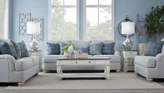 a living room with blue walls and white furniture