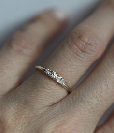 a woman's hand with a diamond ring on top of her finger, showing the band