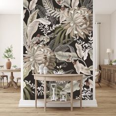 the wallpaper in this room is decorated with tropical leaves and flowers, along with a round table