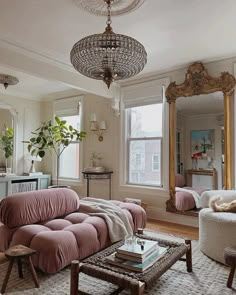 a living room filled with furniture and a chandelier hanging over the top of it