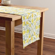 a table topped with a yellow and white table cloth next to a bowl of fruit