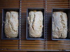 three loafs of bread sitting in metal pans