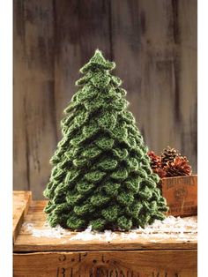 a small green christmas tree sitting on top of a wooden table