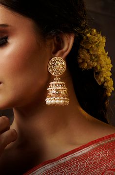 Add a touch of traditional elegance to your ensemble with these dramatic jhumkas in gold, adorned with cascading pearls. Perfect for complementing traditional attire, these earrings exude timeless charm and sophistication. Finish: 22KT Gold Plating Material: Brass, Kundan, Pearls Color: Gold Size: One Size Closure Type: Push Back Box Contains: 1 Pair of Earrings