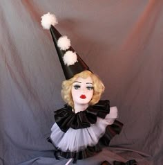 a mannequin wearing a black and white dress with a hat on it's head