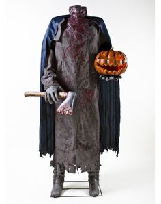 a man dressed as a zombie holding a pumpkin