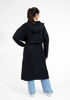 Stay dry and stylish in our women's long black raincoat with a hood. Constructed from a 100% polyester memory fabric, this compact coat is ideal for travel, as it retains it shape after being stuffed into your suitcase. Adjustable drawcords at waist and hood for customizable, feminine styling. Deep inseam side pockets for carrying personal items, impeccably finished with bias bound seaming throughout interior. Water resistant protection from the rain. Built-in travel pocket for packing convenien Travel Raincoat With Double-lined Hood, Solid Color Raincoat With Adjustable Hood For Travel, Solid Raincoat With Adjustable Hood For Travel, Travel Raincoat With Adjustable Hood, Travel Raincoat With Detachable Hood, Black Outerwear With Double-lined Hood For Travel, Black Travel Outerwear With Double-lined Hood, Black Functional Raincoat For Rainy Season, Functional Black Raincoat For Rainy Season