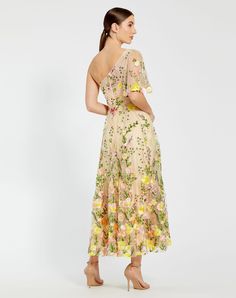 a woman in a floral print dress is looking back at the camera and she has her hands on her hips