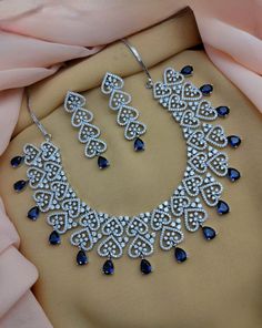 This exquisite silver necklace set features American Diamonds and faux Blue Sapphire with CZ Diamonds, creating the ideal combination of sparkle and elegance. Perfect for any Indian or Pakistani wedding celebration, this necklace offers a timeless addition to your jewelry collection. Diamond Silver Necklace, Blue Combination, Jewelry Pakistani, Diamond Choker Necklace, Silver Diamond Necklace, Silver Necklace Set, Necklace Indian, Diamond Choker, Indian Wedding Jewelry