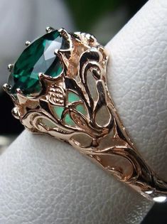 This is a sterling silver filigree ring inspired by Art Nouveau movement of the early 20th century. This beautiful floral filigree ring is set with your choice of a natural or simulated/man-made emerald stone. The natural stone is heat treated for color and clarity. The round full cut emerald is 8mm in diameter. The ring measures 12mm North to South on the finger. The band is marked 925 for sterling silver. Choose rose gold plated or antiqued sterling silver. Rose Gold Sterling Silver Filigree Jewelry, Elegant Rose Gold Jewelry With Intricate Design, Elegant Sterling Silver Ring With Rose Design, Fine Jewelry With Rose Design, Intricate Rose Gold Sterling Silver Jewelry, Classic Rose Gold Emerald Jewelry, Rose Gold Jewelry With Intricate Design For Gift, 14k Gold Rose Design Ring, Ornate Rose Gold Filigree Jewelry