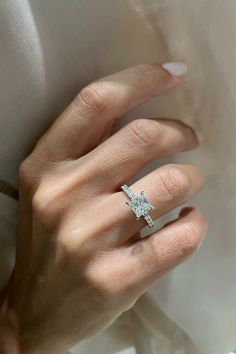 a woman's hand with a diamond ring on it