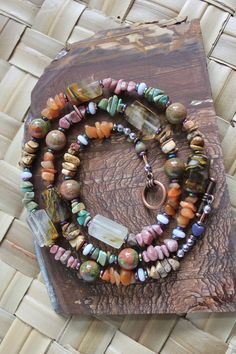 This stunner necklace measures 27.5 inches and is beaded with beautiful blue lace agate heishi beads, barrell style fire quartz beads, unakite round stone beads, and stone chip beads of:  Rhodonite, Turquoise, picture jasper, and aventurine.  Beads are separated with rainbow hematite disc beads and are mixed in between the different variety of stones.   A copper metal toggle clasp with two rainbow hematite hearts and 8 faceted rainbow hematite end beads finish off the design of this truly beautiful necklace. This necklace will make you happy wearing it as it has many different stones.   This is a healing stone necklace design.  It is truly a fun style of necklace to wear and looks great with many different colors.   Necklace is beautiful and was designed and beaded in our shop. Standard Fi Luxury Agate Faceted Beads Necklace, Luxury Traditional Agate Beaded Necklaces, Artisan Jewelry With Ocean Jasper Gemstone Beads, Bohemian Ocean Jasper Necklaces For Gifts, Bohemian Ocean Jasper Necklaces As Gifts, Unique Crystal Necklaces With Round Natural Stones, Spiritual Ocean Jasper Necklaces For Healing, Spiritual Ocean Jasper Jewelry With Natural Stones, Unique Crystal Necklace With Natural Stones