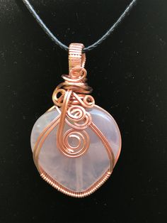 Rose Quartz crystal heart pendant gently wrapped with copper wire.  The heart is like a very pale pink almost cloudy see through stone. I loved wrapping this piece, the unique design is beautiful. Comes with a black necklace 20" with 2" extension. This gemstone is known for its strong vibration of unconditional love, joy, and emotional healing. This gorgeous pink crystal has a powerful energy that resonates within the heart chakra, the area related to compassion.  Powerful to use in meditation a Pink Rose Quartz Wire-wrapped Necklace, Pink Rose Quartz Wire Wrapped Necklace, Pink Wire Wrapped Crystal Pendant Necklace, Pink Wire Wrapped Copper Jewelry, Wire Wrapped Rose Quartz Necklace Gift, Rose Quartz Wire Wrapped Necklace As Gift, Gift Rose Quartz Wire Wrapped Necklace, Gift Rose Gold Wire Wrapped Crystal Necklace, Rose Gold Wire Wrapped Crystal Necklace Gift