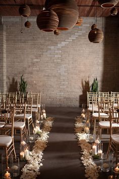 an empty room with rows of chairs and lights hanging from the ceiling