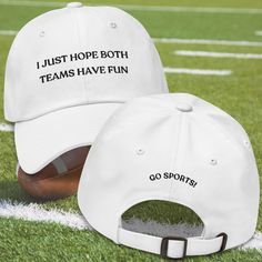 Introducing the "I Just Hope Both Teams Have Fun" hat--your new game day essential! Perfect for the ultimate sports fan who's all about good vibes and great times, this hat blends humor and team spirit effortlessly. With its playful slogan and comfortable fit, it's ideal for cheering on any team, anywhere. Slip it on, spread some positivity, and let the fun begin!  About the hat: Dad hats aren't just for dads. This one's got a low profile with an adjustable strap and curved visor. * 100% chino c White Snapback Hat With Letter Print For Sports, White Sports Fan Hat With Letter Print, Team Spirit Letter Print Cap, White Sports Fan Cap, Game Day Hat With Letter Print And Curved Brim, Football Season Sports Fan Cap, Sports Fan Cap For Football Season, White Letter Print Snapback Hat For Sports Fans, Curved Brim Hat With Letter Print For Game Day