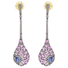 Introducing our Victorian 7.28 Cttw. Sapphire and Diamond Long Drop Earrings in 18K/925 – a captivating blend of timeless elegance and modern design. These exquisite earrings feature a marquise-shaped drop that gracefully dangles, adorned with pear-shaped blue and pink sapphires. Each gem is embraced by a dazzling diamond halo, set against the dark allure of black rhodium. The meticulous arrangement of diamonds on the drop creates a harmonious symphony of light and color, adding depth and dimension to the overall design. The drop is seamlessly connected to the surmount by a row of diamond-studded frames, providing a fluid transition between the elements. The surmount, adorned with additional diamonds, adds a touch of sophistication and completes the ensemble. The closures, crafted from 18k Sapphire Diamond Earrings, Sapphire And Diamond Earrings, Diamond Choker Necklace, Diamond Choker, Blue Sapphire Diamond, Long Drop Earrings, Blue Jewelry, Black Rhodium, Dream Jewelry