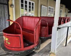 two red children's sleighs sitting on a porch