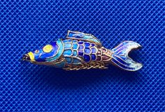 Incredibly beautiful koi fish pendant made of gold plated silver (vermeil) and hand painted  enamel in shades of blue with accents of chartreuse and purple. This pedant is medium size at 2" long and weighing approximately 5.5 grams. It is a 3-dimensonal koi, articulated to allow movement that mimics the swimming body of a fish.   This pendant was made in China in the early 1960s, in a period where many deemed the quality of work to be quite high (pre-cultural revolution). It was purchased in NYC at that time for resale, but was never sold and has been in storage since.  Please see my other listings for more high quality vintage items like this one, including articulated koi fish earrings. We will be adding more items to our shop frequently as well so please stop by again.   Please note buy Swimming Body, Carpe Koi, Koi Fish, Gold Plated Silver, Koi, Gold Vermeil, Shades Of Blue, 1960s, Favorite Jewelry