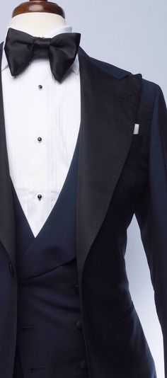 The classic navy tuxedo is a staple of any man's wardrobe. This elegant single-breasted Evening Wear tuxedo is tailored slim from soft, mid-weight, true blue mohair, and features our signature one-button placement, double vents, jetted pockets, natural shoulder, and wide peak lapels in grosgrain. The accompanying slim trousers are flat front with a wide waistband and feature our versatile side adjusters and classic tuxedo stripe. Blue Tuxedo Jacket, Navy Blue Tuxedo, Tuxedo Ideas, Red Overcoat, Brown Chukka Boots, Navy Tuxedos, Blue Tuxedo, Grey Overcoat, Mens Formalwear