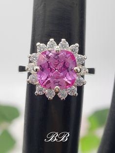 Made to order. Please allow up to 3 weeks for the production of your ring. This listing is for a 925 non-plated sterling silver or non-plated gold halo ring with a lab created pink sapphire center stone. Center Stone Gemstone Type: Lab Created Sapphire Shape: Cushion Cut Size: 8mm Weight: 2 Carat Approximately Color: Pink Quality: AAA Hardness: 9 Mohs Accent Stones Gemstone Type: Lab Created Cubic Zirconia Diamonds Shape: Round Cut Size: (14) 2mm Color: White Colorless Quality: 6A Hardness: 8.25 Mohs Available Metals (All metals are solid and non-plated) 925 Non-Plated Sterling Silver 10KT White Gold (non-rhodium plated) 10KT Yellow Gold 14KT White Gold (non-rhodium plated) 14KT Yellow Gold 14KT Rose Gold Did you know lab-created sapphires are equivalent to natural sapphires? Lab grown sap Luxury Pink Sterling Silver Rings, Sterling Silver Ring With Halo Design, 14k White Gold Jewelry With Prong Setting For Gift, Luxury Pink Sapphire Jewelry For Anniversary, Formal Pink 14k White Gold Jewelry, Dazzling Pink Sterling Silver Ring, Sterling Silver Gemstone Halo Ring For Wedding, Pink Diamond Halo Jewelry, Pink Sapphire Jewelry With Halo Design